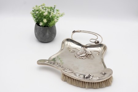 Apanha-migalhas e escova em prata com relevos de motivos florais